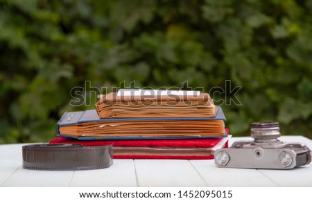 Old photo albums with photographic film on a light wooden table.