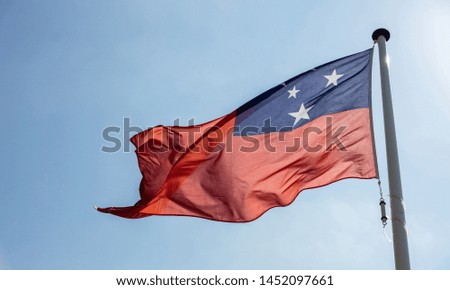 Samoa flag, National symbol waving against clear blue sky, sunny day