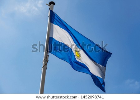 Argentina flag. Argentinian national symbol waving on liberation day against clear blue sky, sunny day