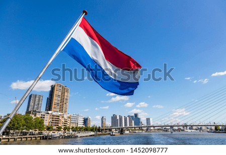 Netherlands flag waving, Highrise buildings background, sunny day in Rotterdam city center
