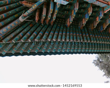 A Wooden roof with Red and Green Korean traditional patterns.