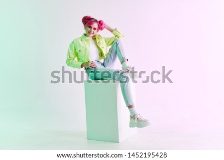 fashionable woman with hairstyle sitting on a cube