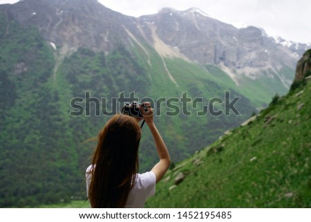 woman with camera snapshots of nature mountains