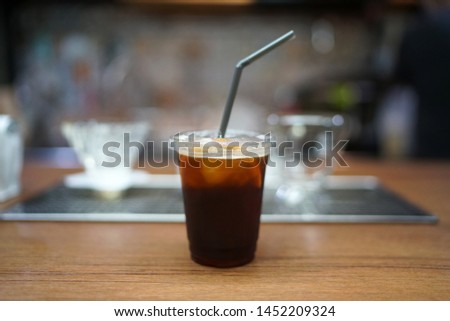 Iced coffee with orange - A plastic glass of espresso shot mixed with orange juice and craft soda on blurred background, Perfect drink for summer time.