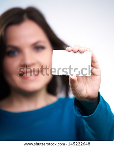 Attractive smiling girl in blue shirt holding a poster,on white background.