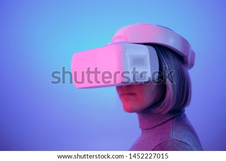 Young Woman Playing on Vr Glasses Touching Air During Virtual Reality Experience Isolated on Blue Background Copy Space Closeup Studio Photo. Girl Having Fun Time with Headset Goggles