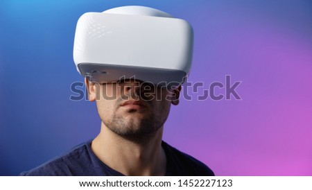 Young Man Playing on Vr Glasses During Virtual Reality Experience Isolated on Blue Background Copy Space Closeup Studio Photo. Man Having Fun Time with Headset Goggles