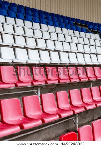 Stadium seats, France flag color. Soccer, football or baseball stadium tribune without fans. End of the game.