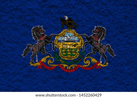 The national flag of the US state Pennsylvania in against a gray wall with stony surface on the day of independence in  blue and yellow. Political and religious disputes, customs and delivery.