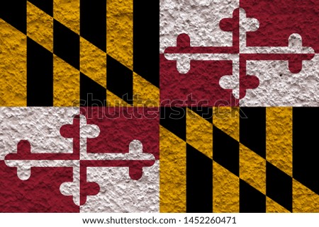 The national flag of the US state Maryland in against a gray wall with stony surface on the day of independence in black, red and yellow. Political and religious disputes, customs and delivery.