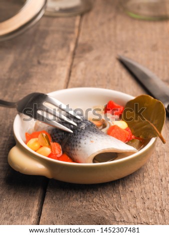 Delicious rollmops in a ceramic bowl on a wooden kitchen table
