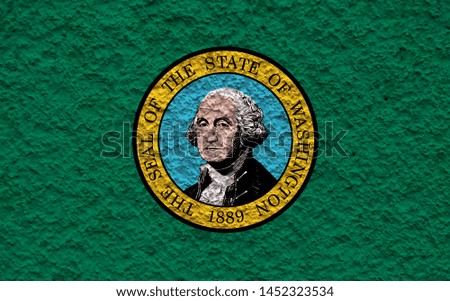 The national flag of the US state Washington in against a gray wall with stony surface on the day of independence in green and yellow. Political and religious disputes, customs and delivery.