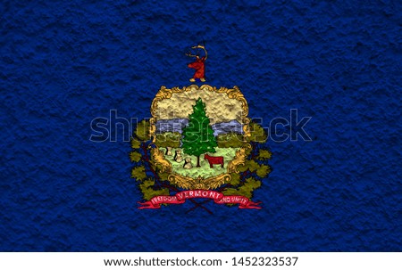 The national flag of the US state Vermont in against a gray wall with stony surface on the day of independence in colors of blue and yellow. Political and religious disputes, customs and delivery.