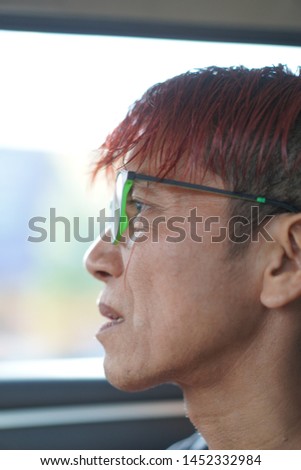 The man with red hair wear glasses looking hopefully past the camera,The eye of man in Asia and Glasses accessories personality to look good for all ages.in-Thailand.