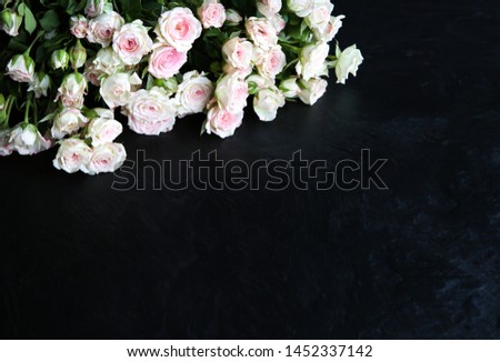Beautiful flowers on black background. Roses bouquet. Perfect flat lay. Happy mother's holiday postcard. International women's day greeting. Stylish idea for advert or promotion.