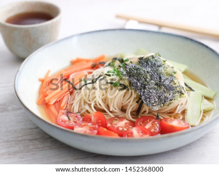 Cold zaru noodles made with a spaghetti angel hair with cold soy mirin sauce with mixed vegetables such as carrots, cucumber and cherry tomatoes. A fresh chilling traditional Japanese summer dish