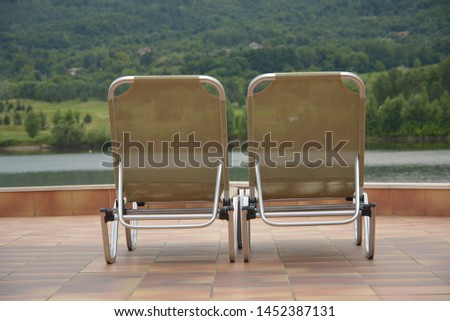 Two sun loungers across a lake