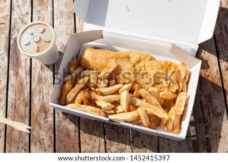 Traditional British Fish and Chips in a Box on a Wooden Table. Royalty-Free Stock Photo #1452415397