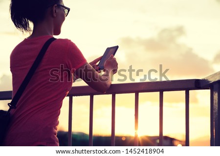 Woman use smartphone in sunset Hong Kong