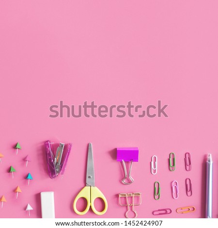 Various stationeries at the bottom of pink background