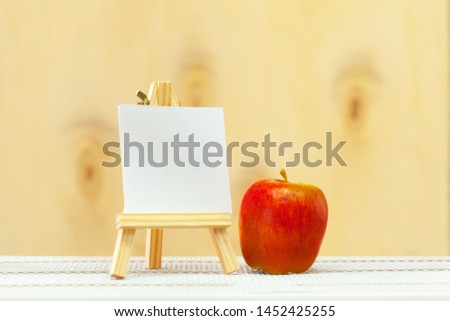 Blank mini canvas on easel on wooden table, copy space