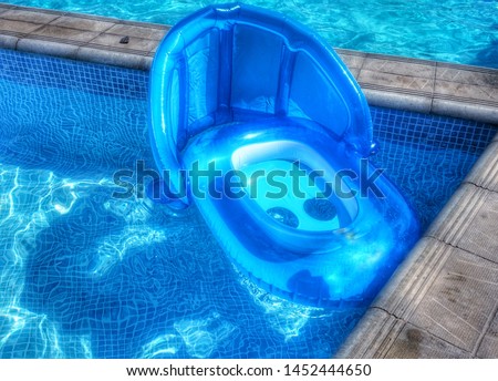 Inflatable children's circle swims in the pool.