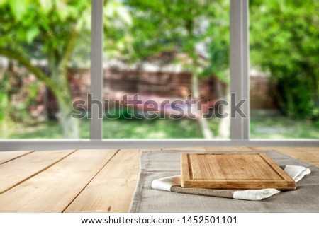 Table background wooden board and garden behind the window and sunrise in the morning