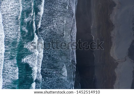 Aerial drone view of ocean waves washing black basaltic sand beach, Iceland Royalty-Free Stock Photo #1452514910
