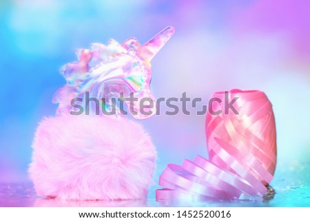 Shiny zine type gradient holographic iridescent head of pink soft fluffy toy unicorn on bright blue pink bokeh fluorescent neon background. Celebration birthday greeting card concept with copy space