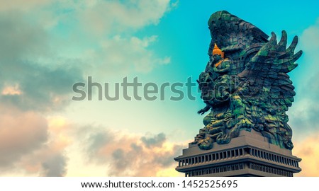 Landscape picture of tallest Garuda Wisnu Kencana GWK statue as Bali landmark with blue sky as a background. Balinese traditional symbol of hindu religion. Popular travel destinations in Indonesia.