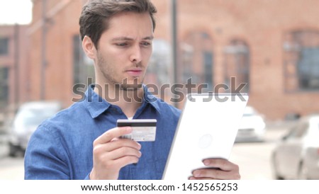 Outdoor Portrait of Young Man Shopping Online on Tablet
