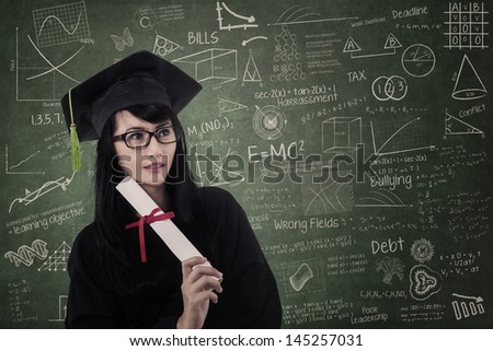 Attractive nerd female graduate wearing gown at class