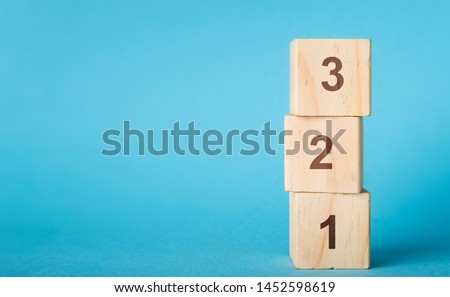 Wooden alphabet number blocks 123 on blue background, copy space Royalty-Free Stock Photo #1452598619