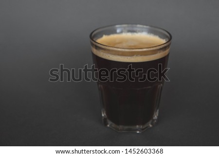 large transparent glass filled with of aromatic filter americano coffee photographed on the isolated gray background picture for the menu
