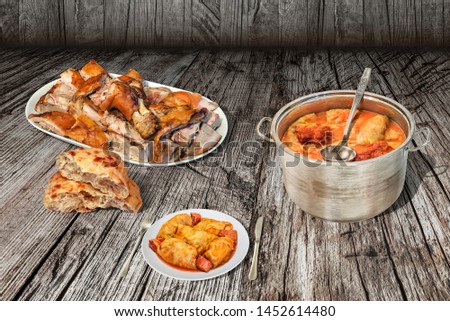Gourmet Pickled Cabbage Stuffed Rolls Served with Plateful of Freshly Spit Roasted Pork Meat and Pita Leavened Flatbread on Old Weathered Rustic Pinewood Table
