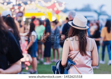 Soft light and Blur image
,The back of an Asian woman wearing a bamboo-made hat and walking in a food festival with concerts on a blurred background of lights, bokeh, concert stage