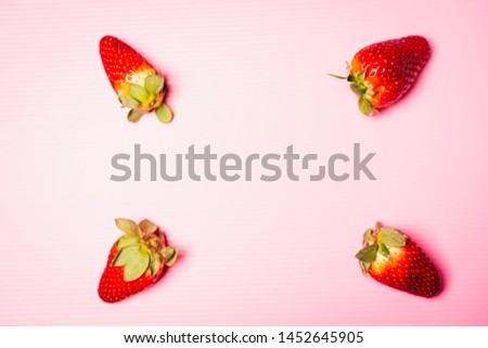 Flat lay composition of strawberries with pink background, top view, copy space for text