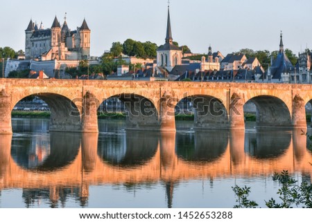 Views of the city of Saumur from the riverbank at dusk, with the castle in the background. Loire Valley, France. Royalty-Free Stock Photo #1452653288
