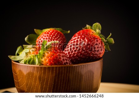 Fresh strawberries served on a wooden bowl, closed up, selective focus