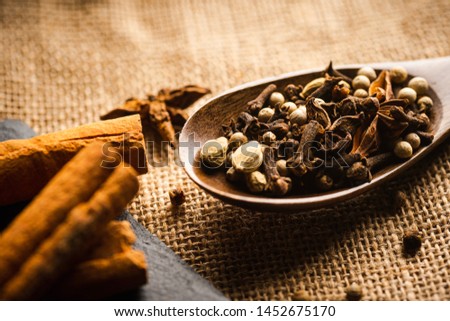 Various spices on a wooden spoon on top of a rag