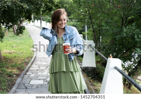 young girl drinking coffee on the street and walking