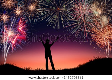 Silhouette of young woman cheerful with happy new years firework display background. Conceptual image of freedom and successful in New year.