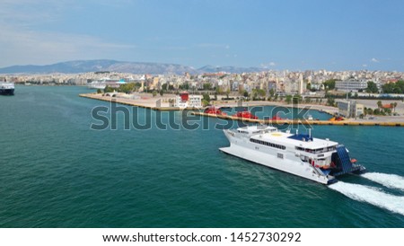 Aerial drone photo of high speed passenger catamaran ferry approaching in low speed iconic port of Piraeus, Attica, Greece Royalty-Free Stock Photo #1452730292