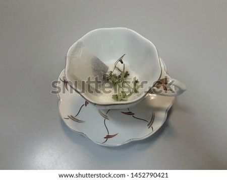 tea bag, sugar and dried mint leaf in a mug
