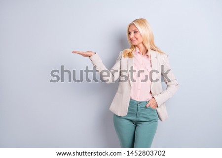 Portrait of her she nice-looking attractive content cheerful gray-haired lady holding copy space on palm ad new novelty promotion isolated over light white gray pastel background