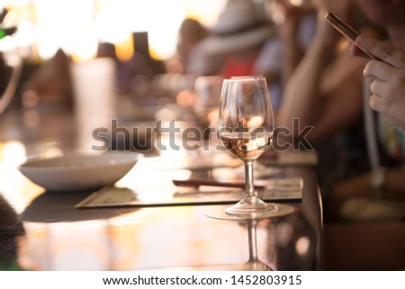 man taking picture of wine glass on his smartphone, banquet hall background