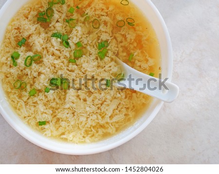 Egg drop soup also known as egg flower soup made of beaten eggs drizzled in homemade chicken broth with scallion greens. Royalty-Free Stock Photo #1452804026
