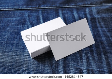 Mockup of blank business cards on denim background.