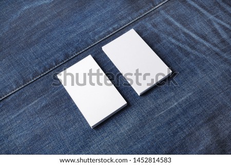Stacks of white blank business cards on denim background. Template for graphic designers portfolios.
