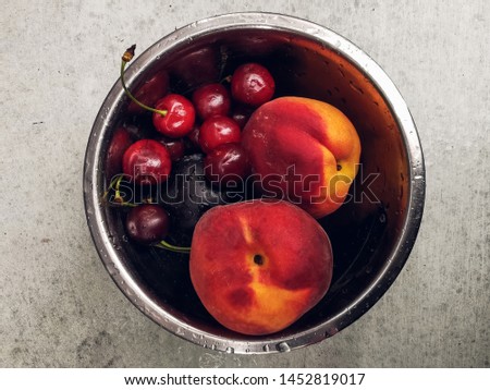 Fresh ripe summer berries and fruits, peaches, apricots, cherry and strawberry in a round plate